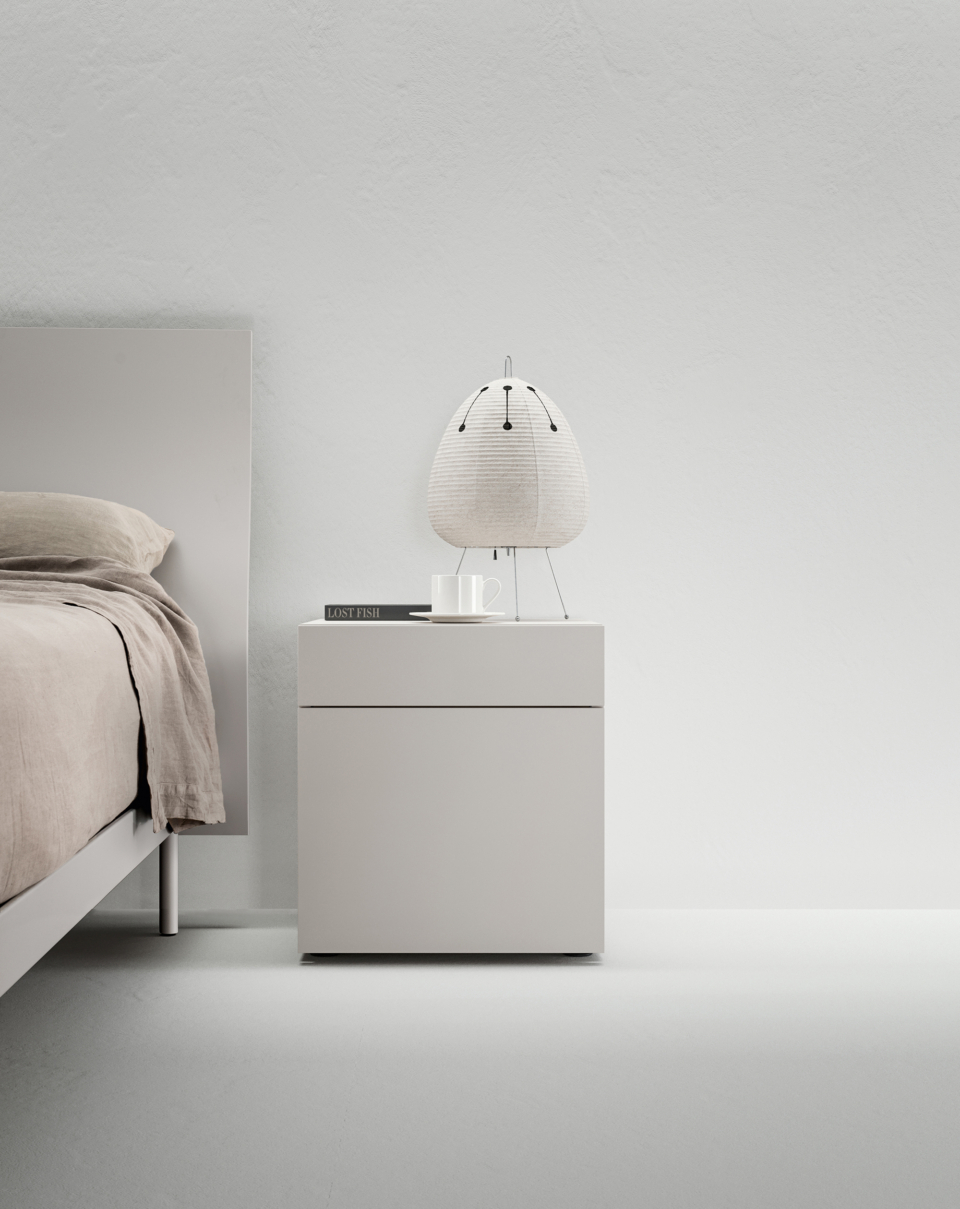 An interplay of lines is the protagonist of this composition. Filnox bedside table is essential and configurable according to your needs. Resting on the floor, according to tradition, with a touch of freshness given by the Rugiada finish. 
It comes with a small drawer and a larger container to store your favourite books to read before falling asleep or in which to store your pyjamas. 